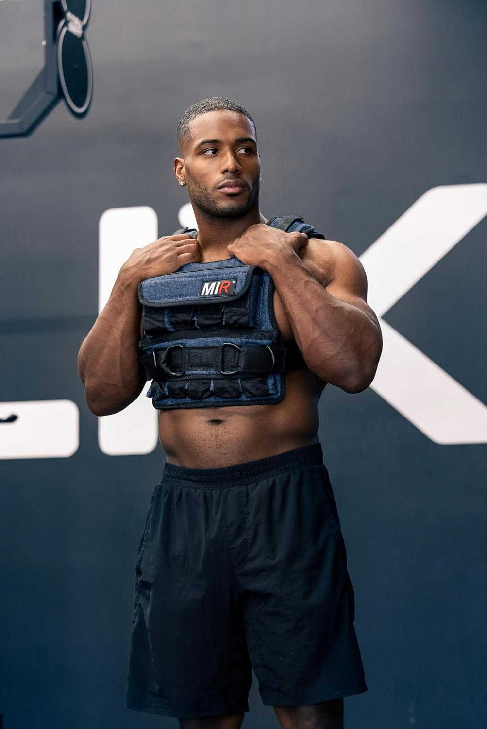 Person wearing a dark miR weighted vest with front pockets and a wide waist strap